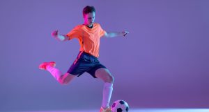 formacion-jugador-futbol-masculino-futbol-masculino-joven-caucasico-aislado-pared-rosa-azul-degradado-luz-neon-scaled-1.jpg